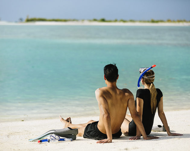 couple sitting on the beach at Naladhu