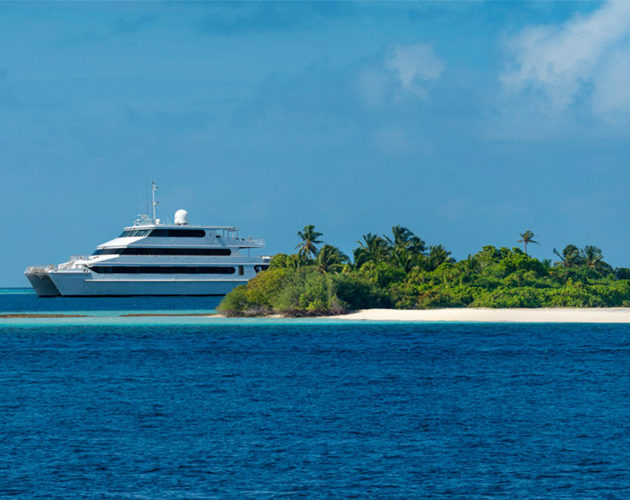 The Four Seasons Explorer Boat sitting off a deserted islands