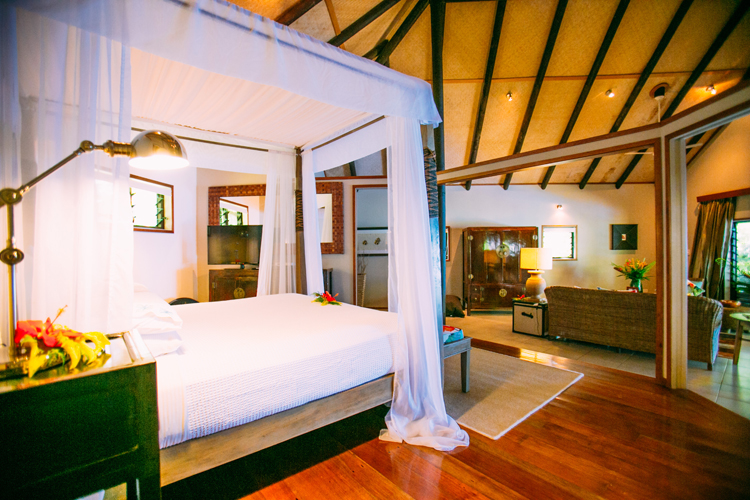 Interior of bedroom and living space in Royal Beach House at Qamea Resort & Spa, Fiji