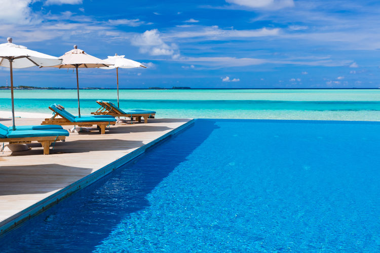 Anantara Dhigu Deck chairs and infinity pool overlooking amazing tropical lagoon